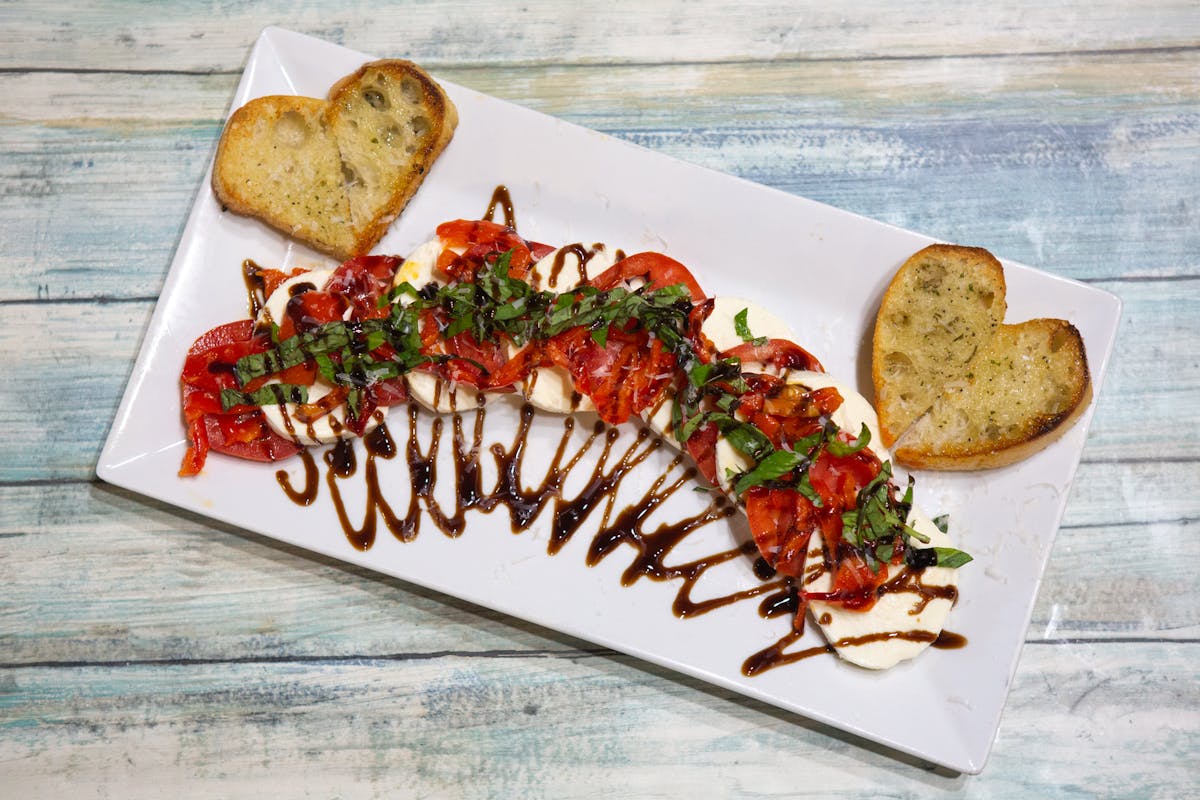 Caprese Salad with fresh mozzarella, tomato, basil, and balsamic glaze on toasted Italian bread — appetizer at Amici Brick Oven Pizza, West Palm Beach