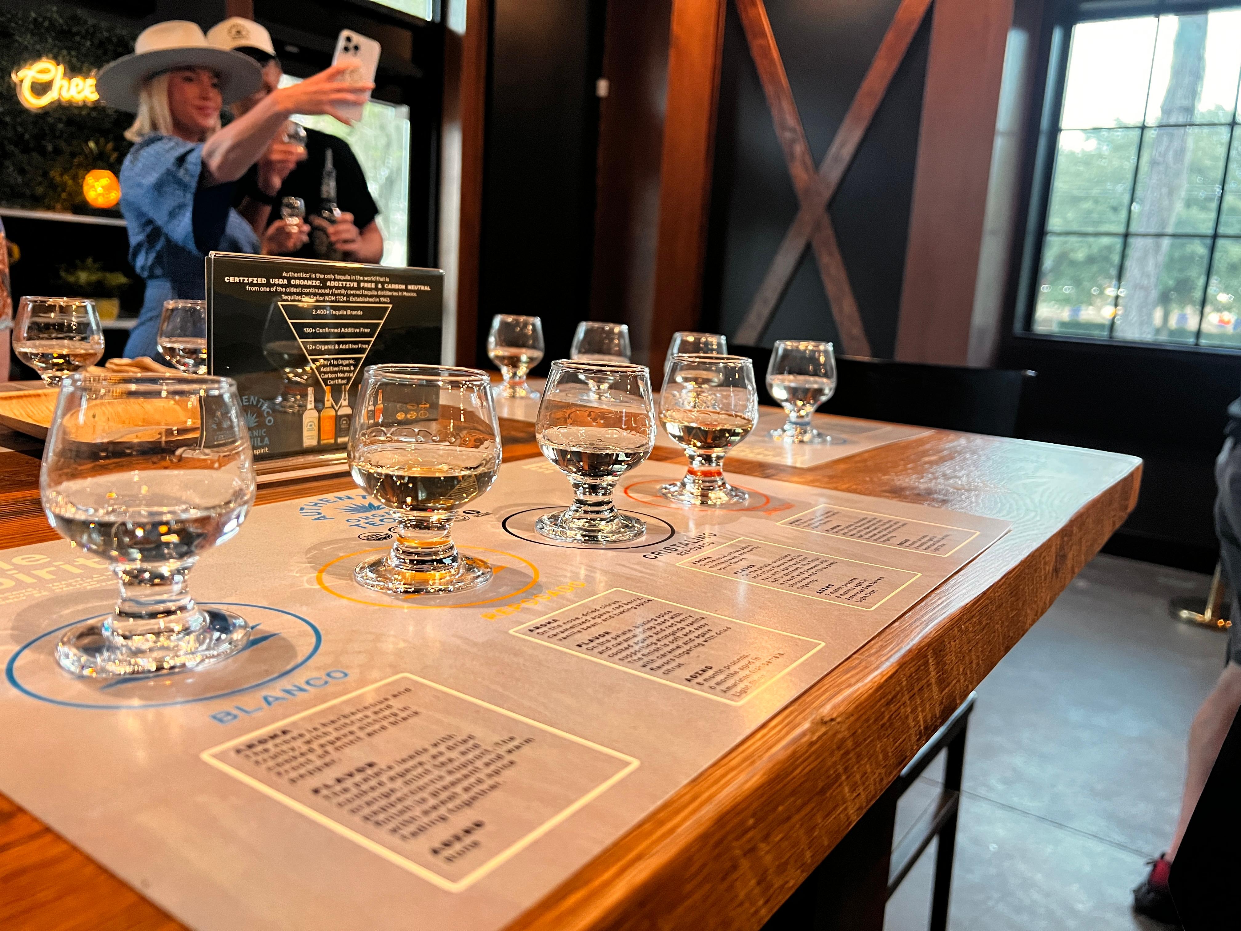 A flight of Authentico tequilas, blanco, repo, anejo and cask still strength on a paper with product details